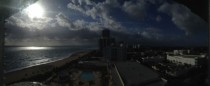 Sunny beach front to a stormy city  