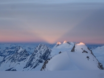 Sunset light V shining through mountain notch Combatant Col Mt Waddington BC Canada 