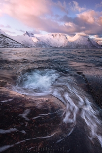Swirly water during a pink sunrise in the arctic cold Storsteinnes Norway 