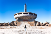 The abandoned and graffitied House-Monument of the Bulgarian Communist Party situated atop Buzludzha Peak in the Central Balkan Mountains Above the doors some people wrote Never Forget Your Past and Communism in Coca-Cola script Photographed by Roman Robr
