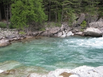 The frigid blue water of Macdonald Creek in Glacier National Park Montana 