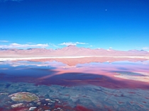 The moon over the beach of a mineral rich salt lake in the Bolivian altiplano 