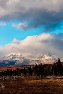 The mountains of Glacier National Park surrounded by clouds and fading sunlight Polebridge MT 