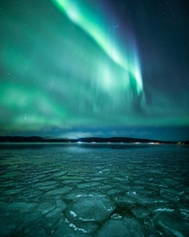 The Northern Lights hover over a frozen lake in Alaska 