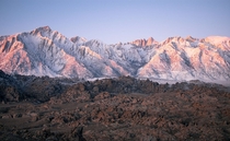 The pink glow of sunrise looking up at Mt Whitney California rising up at  