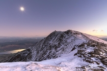 The sun setting behind Coniston Old Man as the moon rose over the water The Lake District 