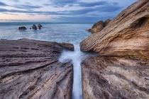 The water in this long exposure photo made a cross in the rocks Mount Maunganui New Zealand 