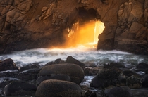 Warm light rays shining through Keyhole Rock at Pfeiffer Beach California -  OC