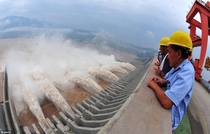 Workers watch as water is released from a gigantic hydropower project on the Yangtze river in Yichang central Chinas Hubei province
