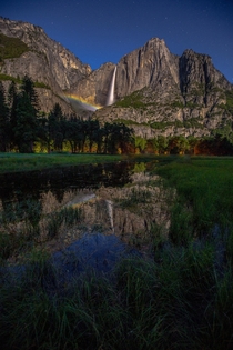 Yosemite Fall glimmering with a moonbow in its mist 