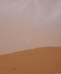 You are looking at moon Phobos setting behind Mount Sharp on a cloudy Martian day captured just a few days ago by the Mars Curiosity Rover with its MastCam camera at pm local time